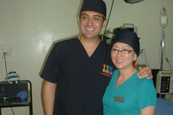Dr. Cynthia Lopez and Dr. Alfredo Hoyos in surgical scrubs in the OR