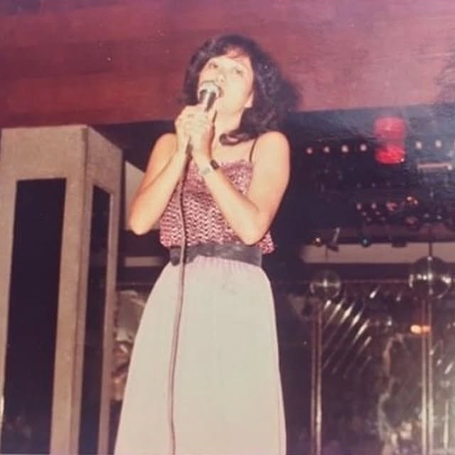 Dr. Cynthia Lopez performing on stage as a singer during her medical internship in the Philippines